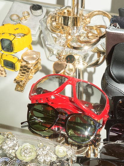 Dior, Céline, and Illesteva sunglasses and Oscar de la Renta costume jewelry collection on a table