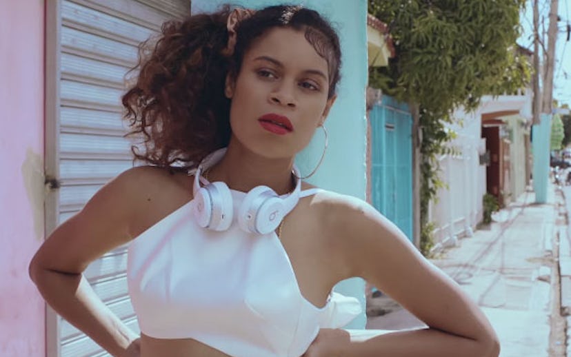 Singer-songwriter Aluna Francis from AlunaGeorge wearing a white shirt, large hoop earrings with whi...