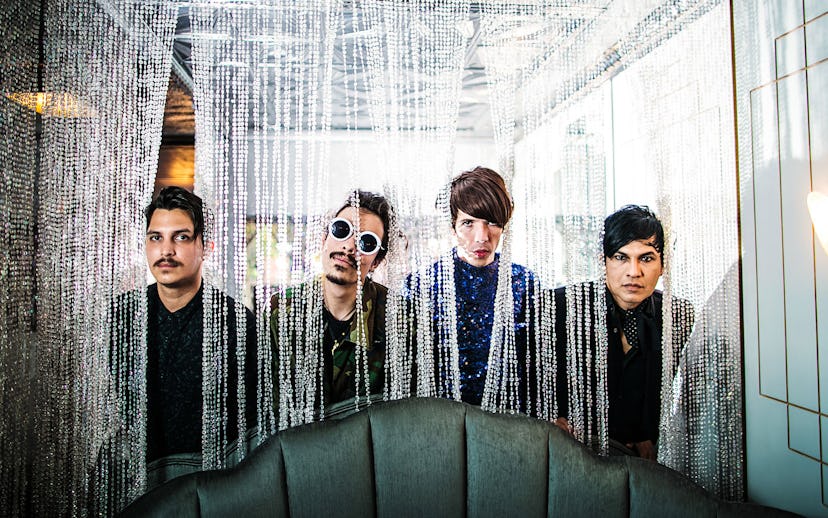 Members of Lazy Queen posing behind a couch