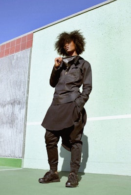 A model in items from Ari Fitz x Reebok Classic Collaboration Collection posing against a wall 