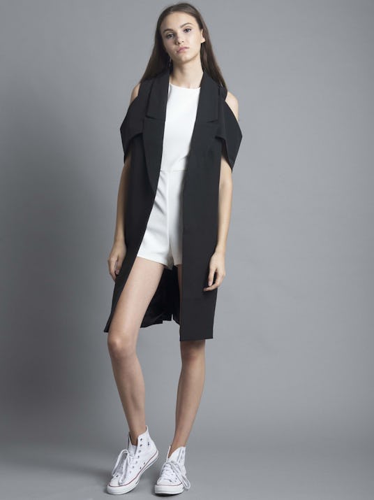 A model in the Lavish Alice black open sleeve duster coat with a white top and shorts underneath 