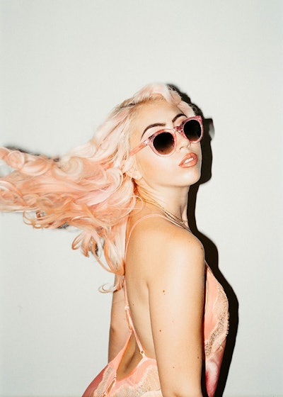 Model with pink hair wearing pink Crap Eyewear sunglasses. 