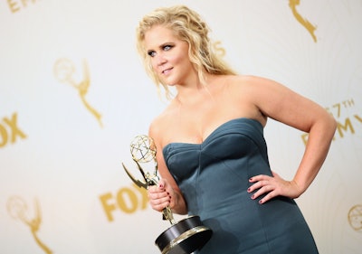 Comedian Amy Schumer holding her Emmy award in a grey sleeveless silk dress  at the 67th annual Prim...