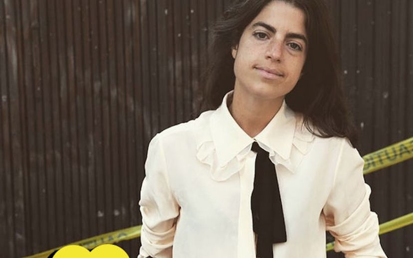 Leandra Medine in a ruffled white button-down, a black tie and jeans