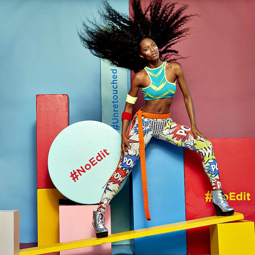 A female model with an afro hairstyle and white lines under her eyes posing in a colorful combinatio...