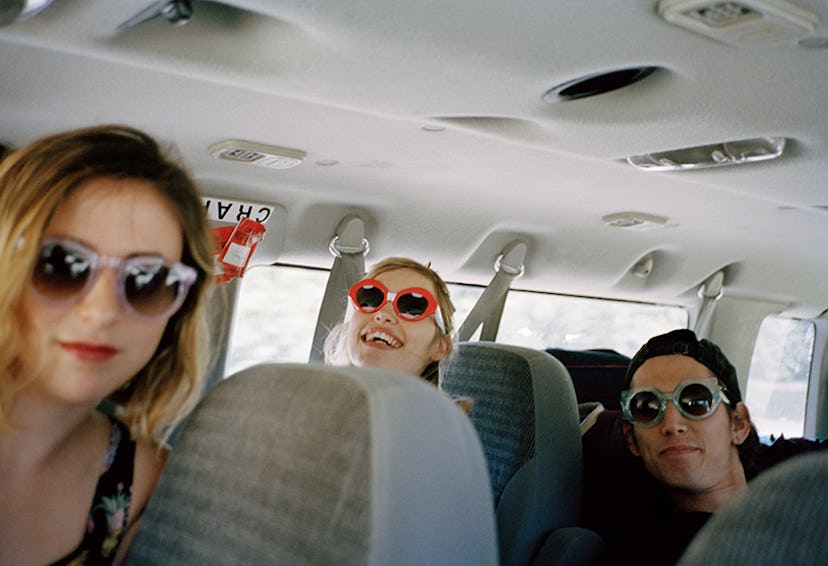 The Paranoids sitting in a van on a road trip wearing Crap Eyewear and smiling