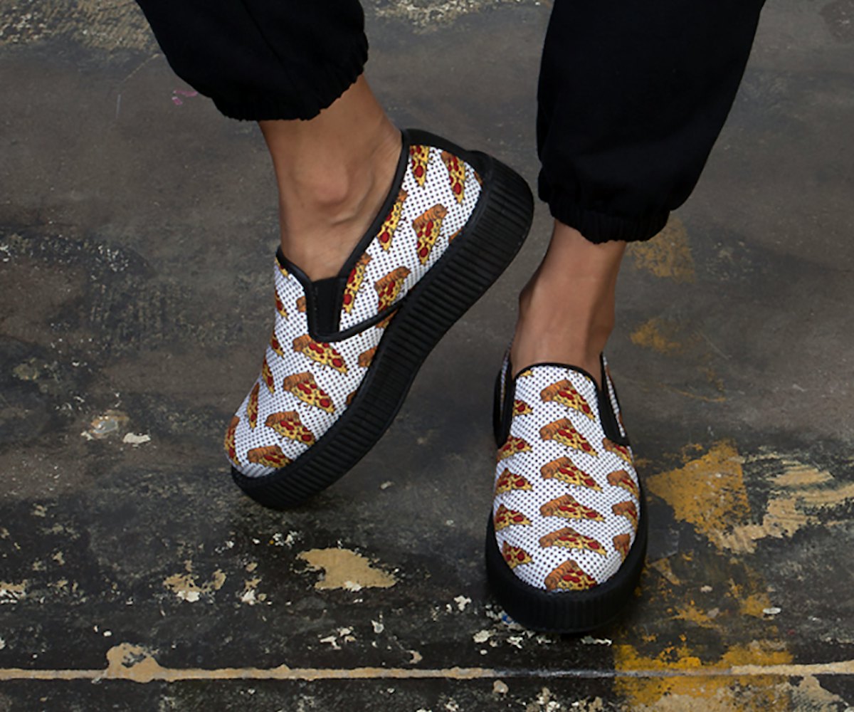White and black slip-on creeper shoes with pizza slice print and a white surface with small black do...
