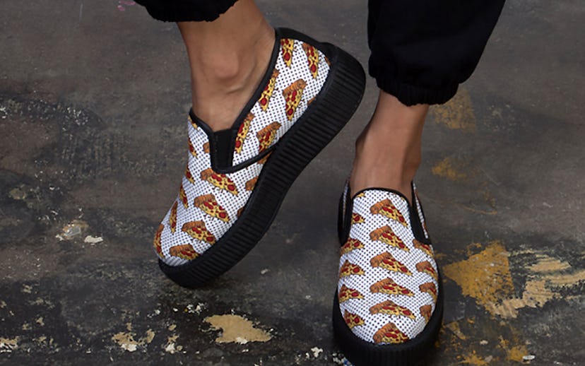White and black slip-on creeper shoes with pizza slice print and a white surface with small black do...