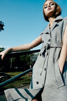 Model posing in a grey jacket by Lacoste
