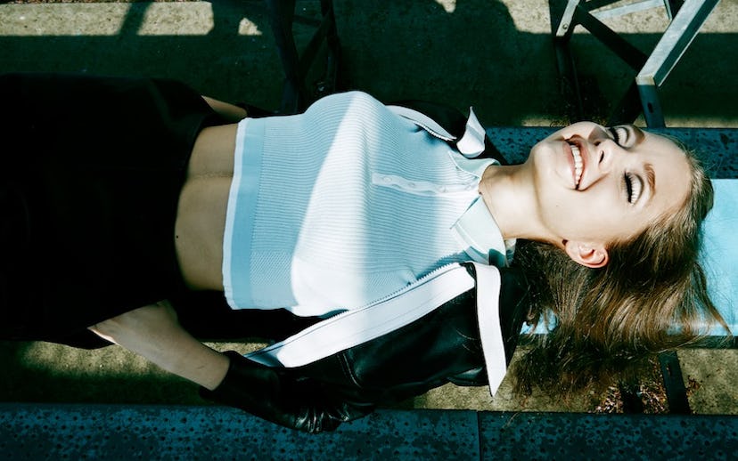 Model sunbathing in a shirt by ASOS, leather jacket, and shorts by Carven