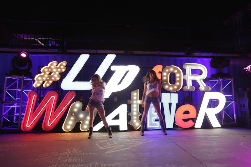Two girls posing in front of the #upforwhatever sign