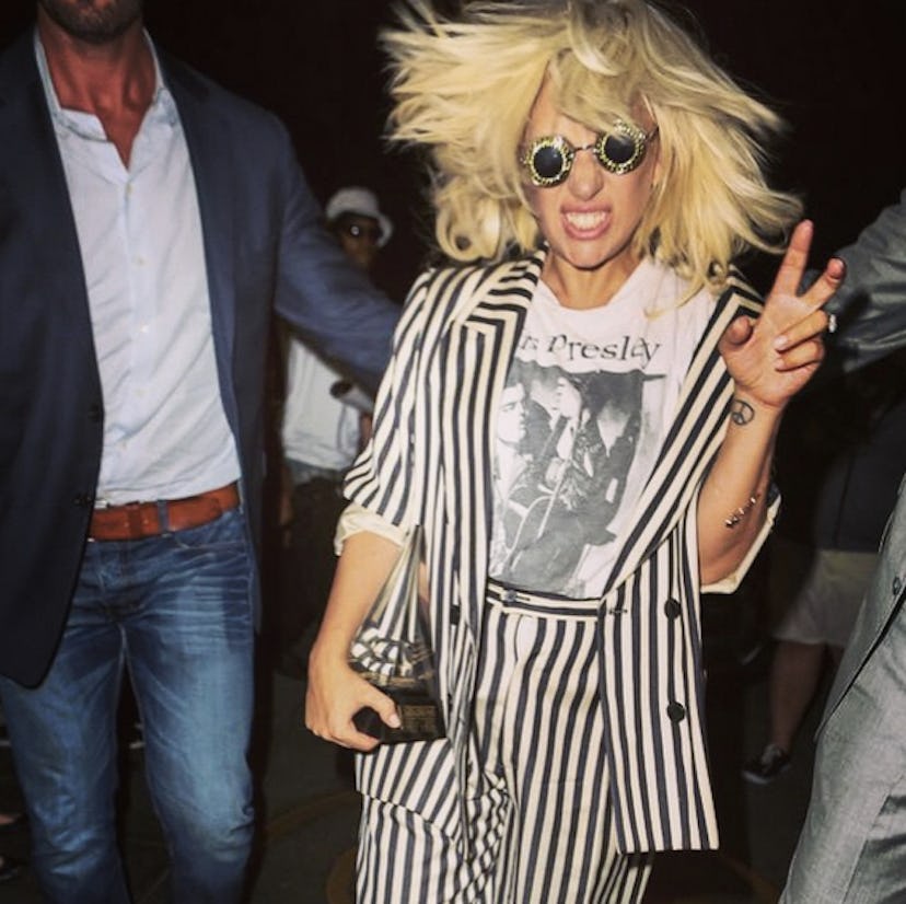 Lady Gaga with her Contemporary Icon Award rocking out with crazy hair and sunglasses