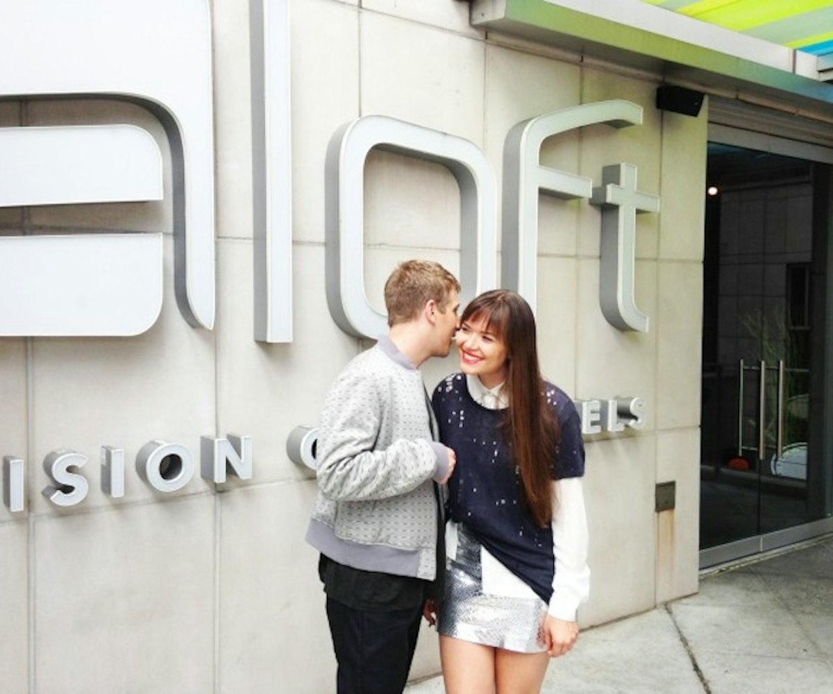 A couple standing in front of an Aloft hotel