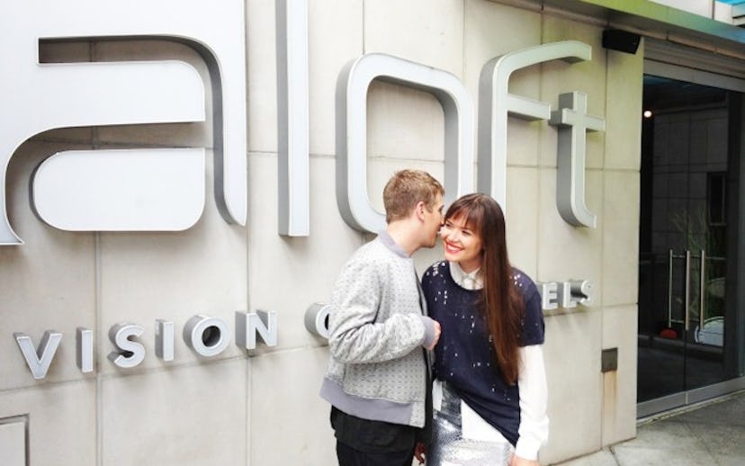 A couple standing in front of an Aloft hotel