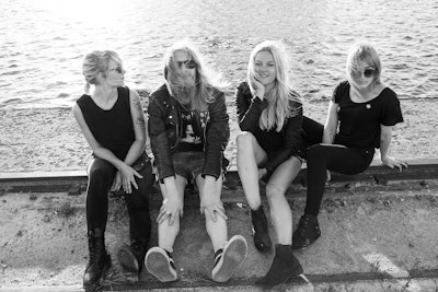 Group picture of Finnish band The Splits consisting of Helena, Maiju, Kiti and Aiju sitting by the s...