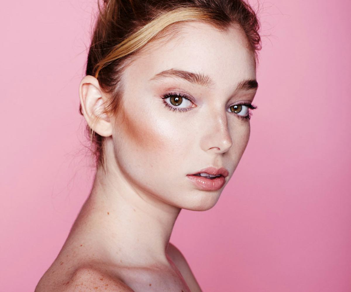 Woman with exfoliated skin wearing only makeup and her hair in a bun