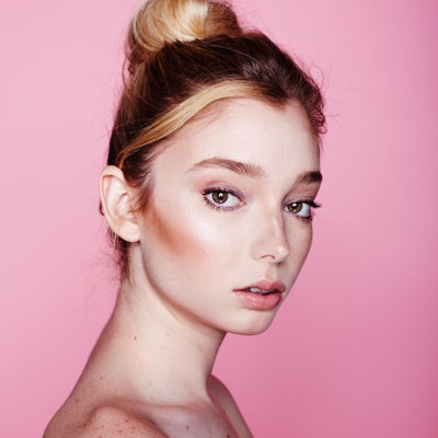 Woman with exfoliated skin wearing only makeup and her hair in a bun