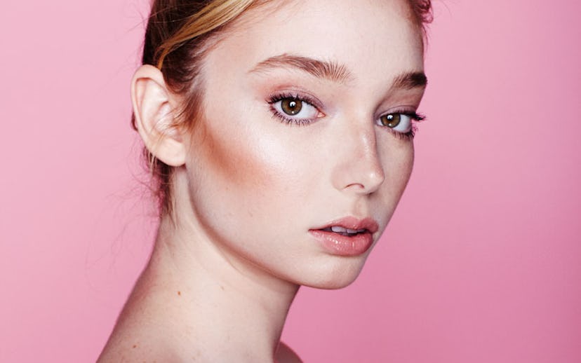 Woman with exfoliated skin wearing only makeup and her hair in a bun