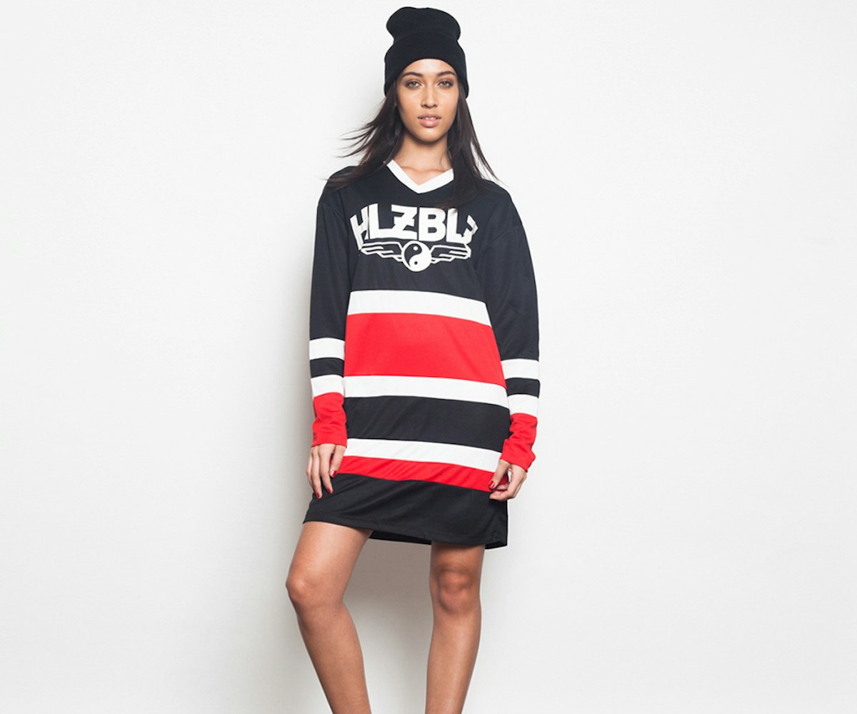 A model in  a black, white, and red striped dress and a black beanie from the NYLON shop x HLZBLZ gi...