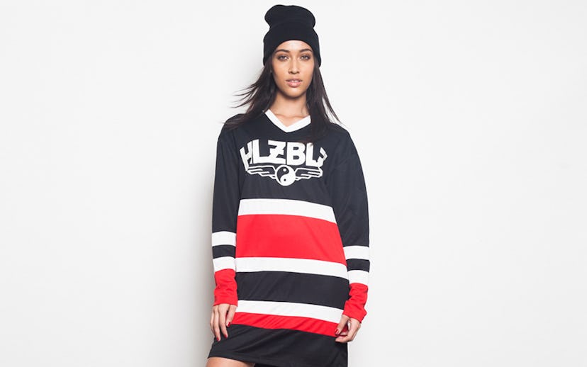 A model in a black, white, and red striped dress and a black beanie from the NYLON shop x HLZBLZ gi...