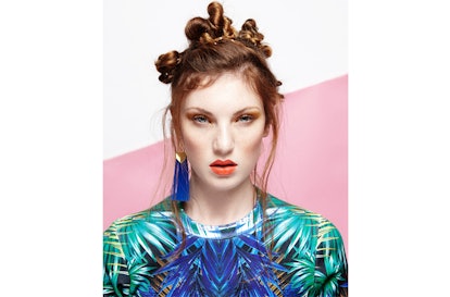 A model wearing a Melody Ehsani jungle gurl top and Suzywan Deluxe long tassel earrings
