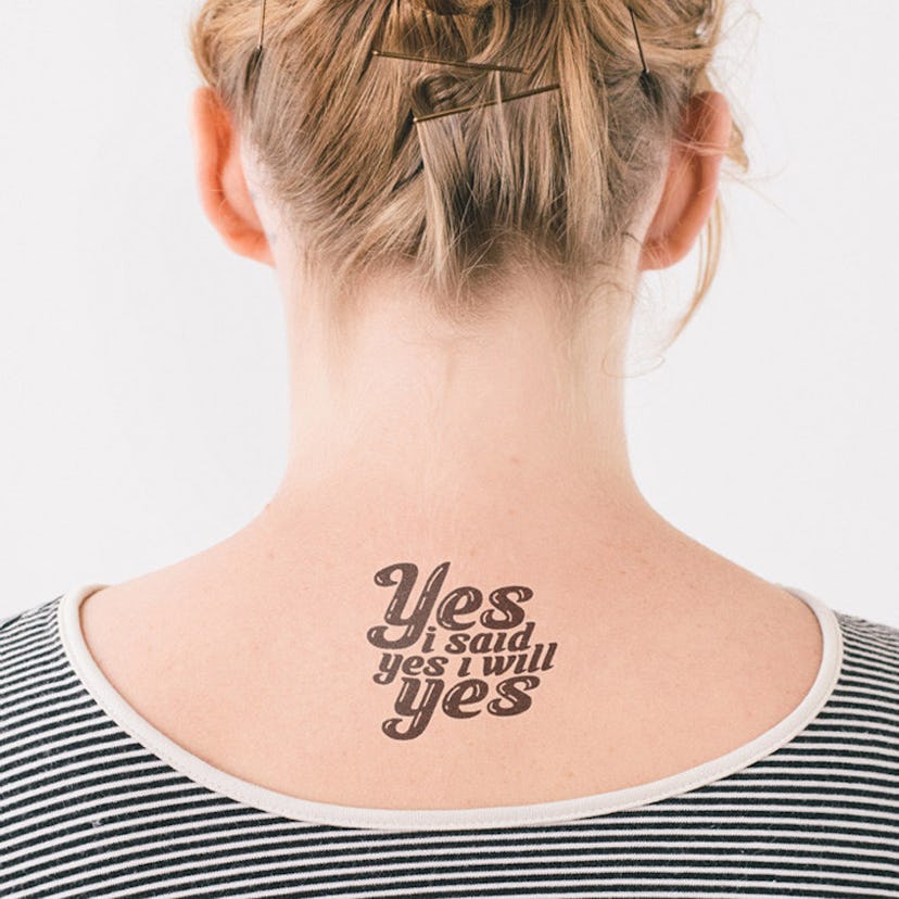 "Yes I said yes I will yes" tattoo on the back of a blonde woman