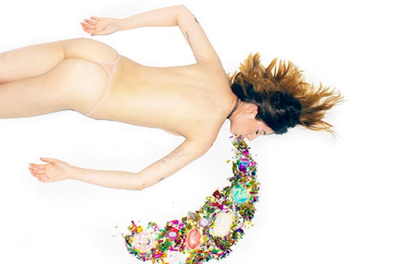 Half naked girl lying on the floor while throwing up confetti
