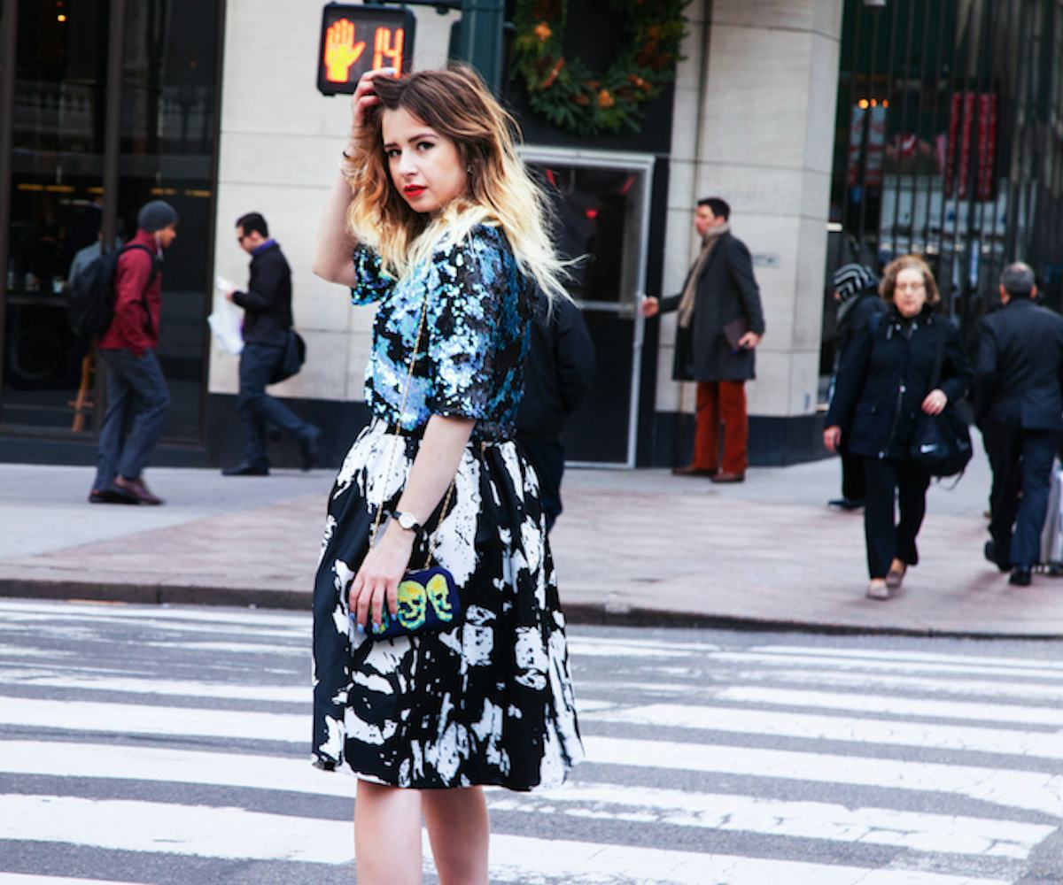 Monica Barleycorn wearing a black and white dress with a short sequin jacket and a small purse with ...