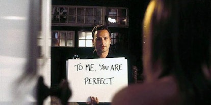 Andrew Lincoln holding a "To me, you are perfect" poster in a "Love Actually" movie scene