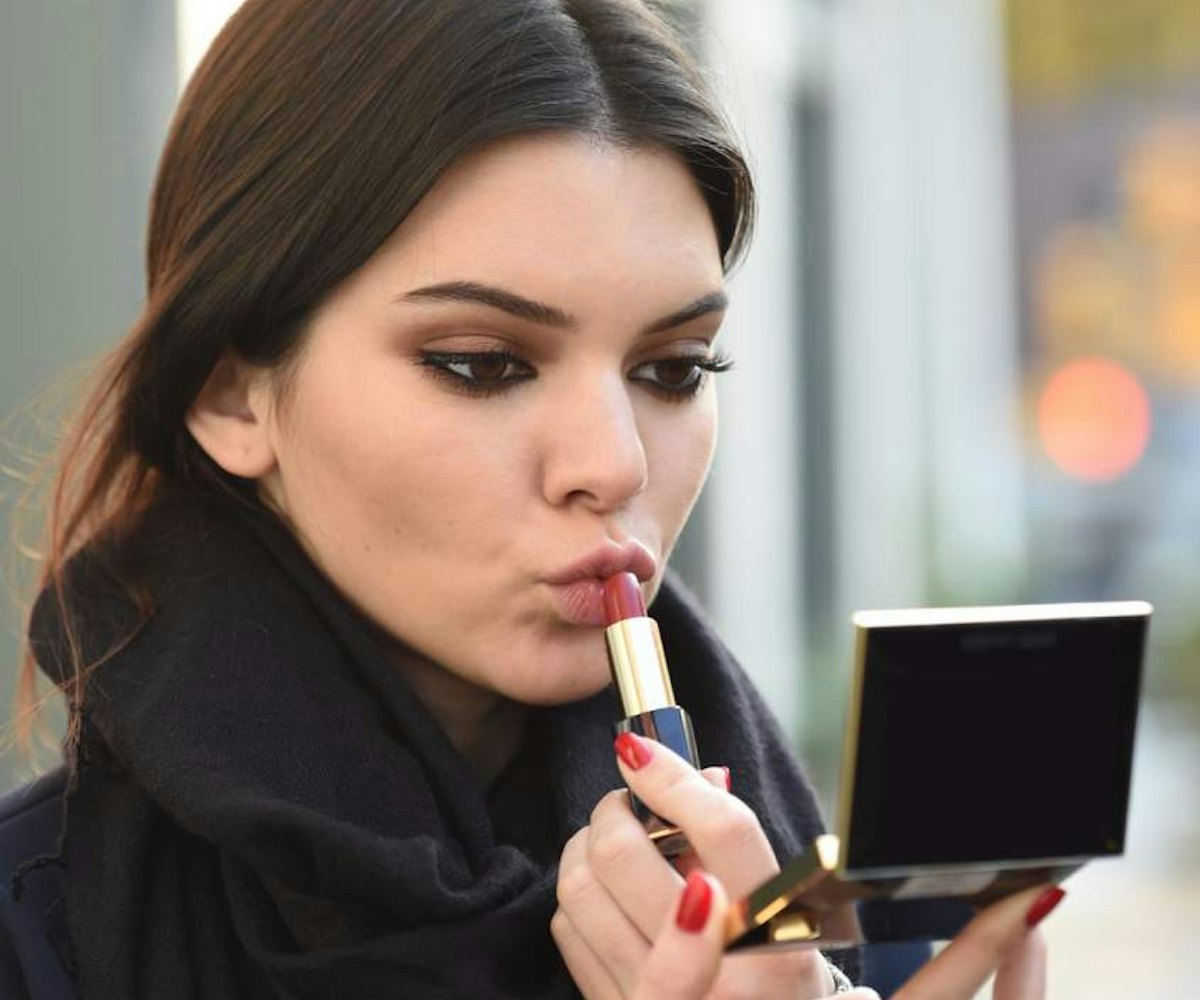 Kendall Jenner putting on nude lipstick