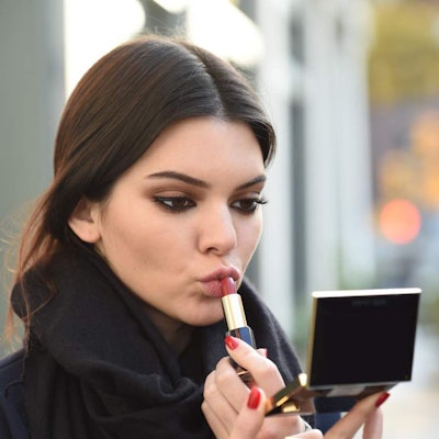 Kendall Jenner putting on a nude lipstick