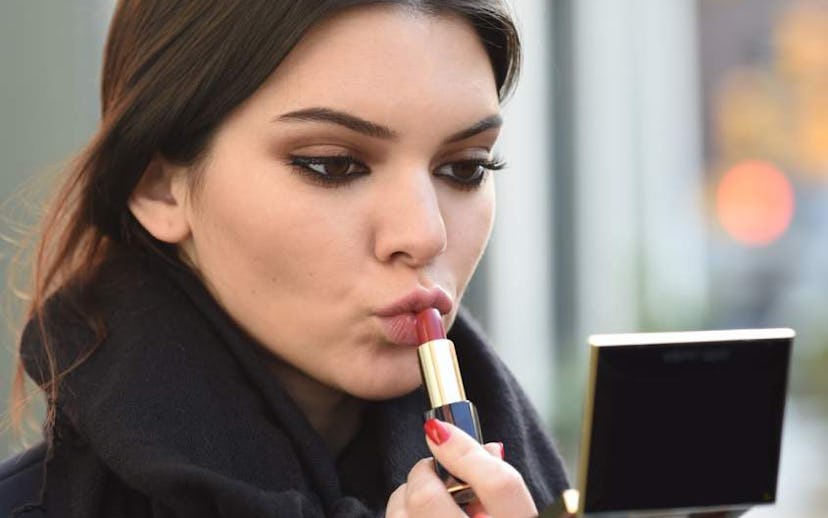 Kendall Jenner putting on nude lipstick