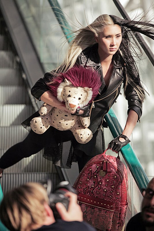 America’s Top Model contestant Shai posing on the escalator while wearing an all-black outfit