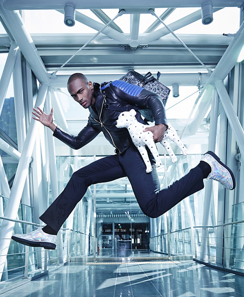 America’s Top Model Keith Carlos posing in a jumping pose while holding a dalmatian dog toy