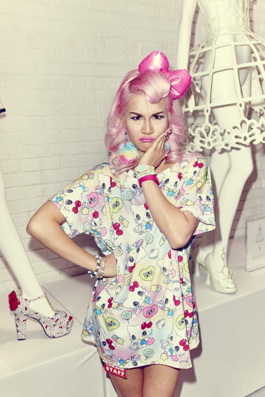 A young lady with pink hair and a matching bow posing while dressed in an oversized Hello Kitty t-sh...