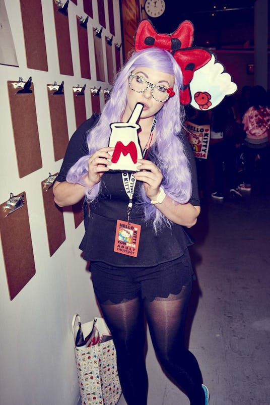 A young woman with purple hair and a Hello Kitty-themed bow