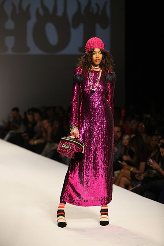 Top Model contestant walking down a runway while wearing a long sparkling purple dress