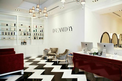 The waiting are at Dreamdry, with black and white floors, a burgundy chair and two beige chairs 