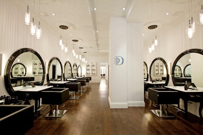 The blow dry stations at Rachel Zoe's dry bar with black leather chairs and circular mirrors