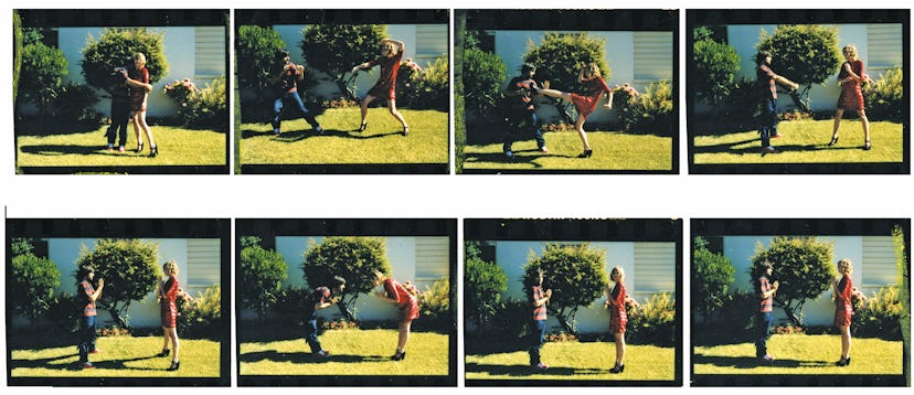 Jason Schwartzman and Kirsten Dunst fake fighting and hugging on grass