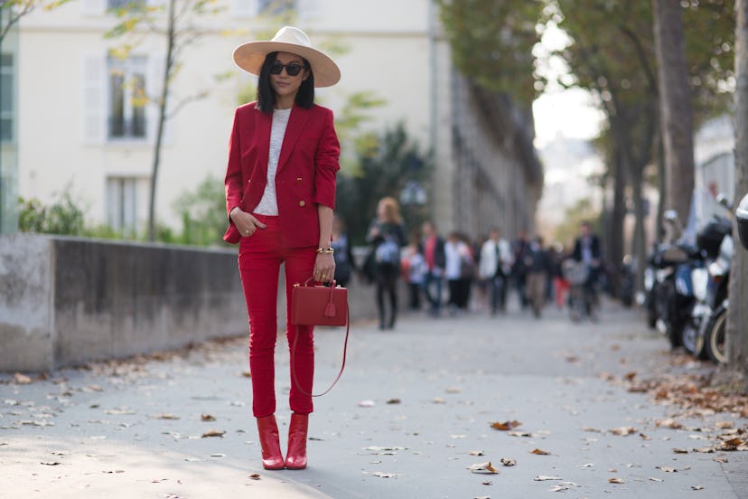 Black haired lady in a red formal suit and a brown straw hat in Paris