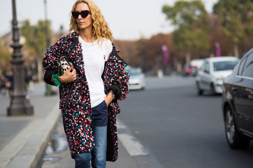A blonde girls wears a street style colorful coat and a white shirt