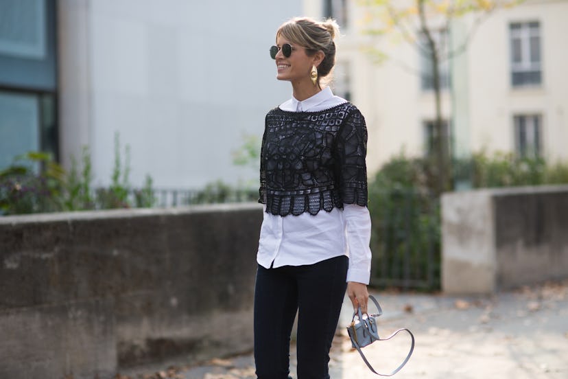 Black blouse over a white shirt worn by a young blonde lady in Paris