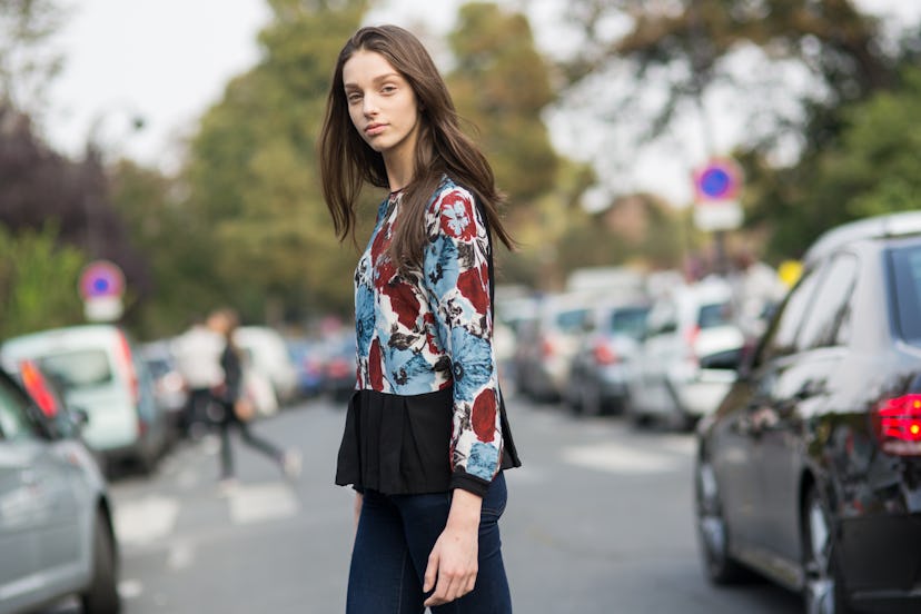 Young brunette wearing a red and blue floral long-sleeved blouse