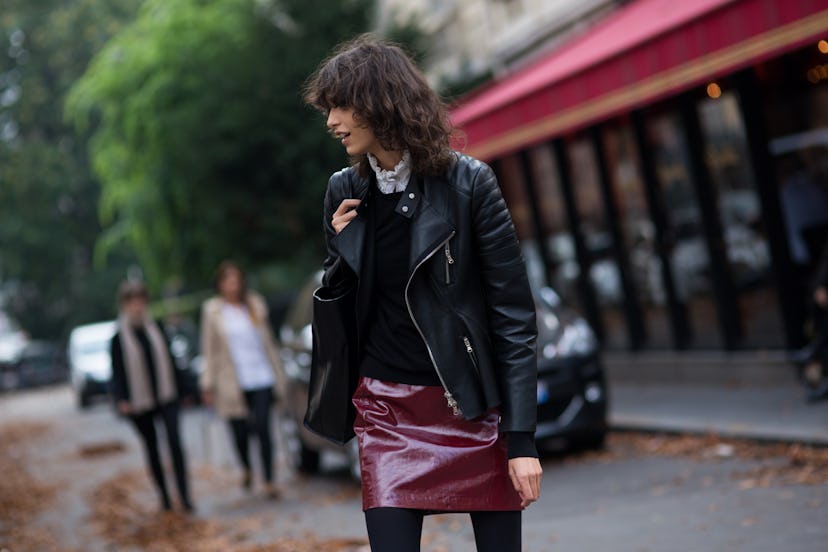 Young and black-haired lady walking in black jacket and red skirt