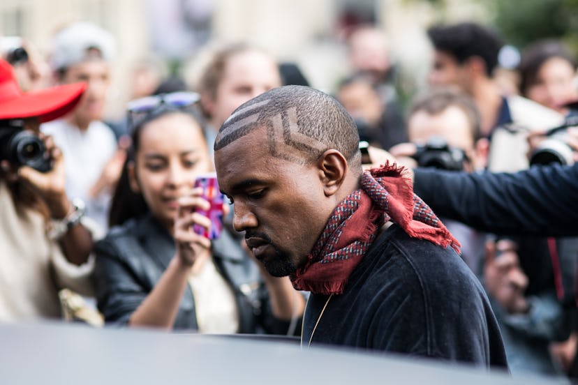 Kanye West in a street style outfit with a red scarf and black shirt