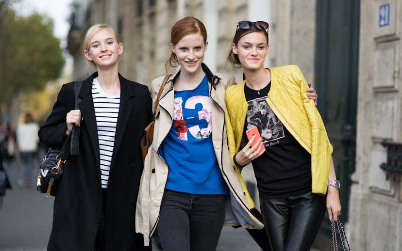 Three female friends in street style outfit on the streets of Paris