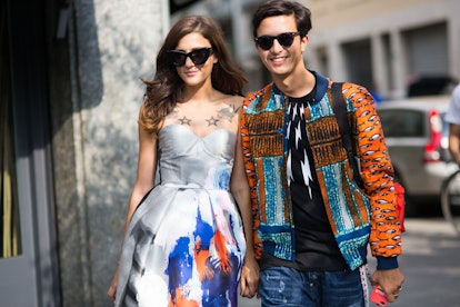 Eleonora Carisi and Alessandro Enriquez holding hands and wearing colorful outfits by photographer M...