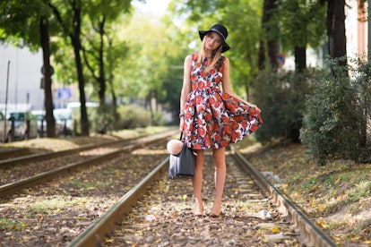 Sonya Esman showing of her printed 50s style dress and big hat on train tracks by photographer Micha...