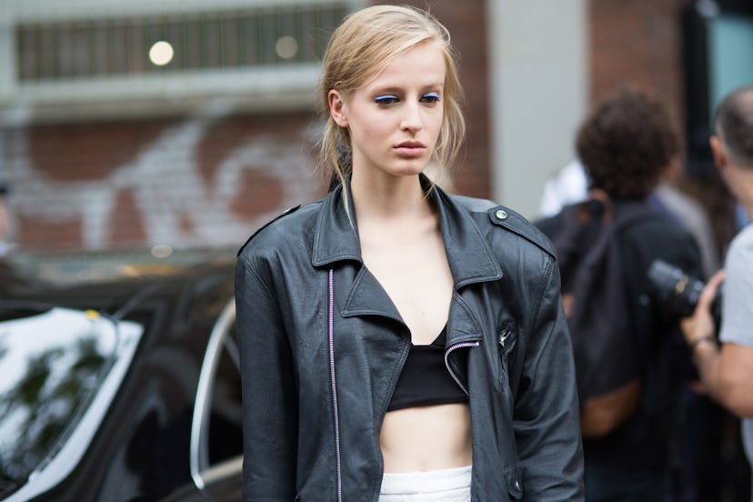 A blonde girl in a black top and leather jacket in Milan during fall